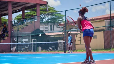 A woman on a tennis ball court