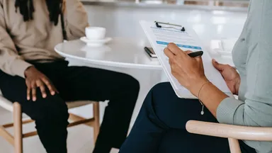 Man is interviewed for a job at a table
