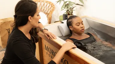 A woman taking a cold plunge at a spa.