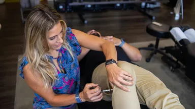A patient and physical therapist at physical therapy