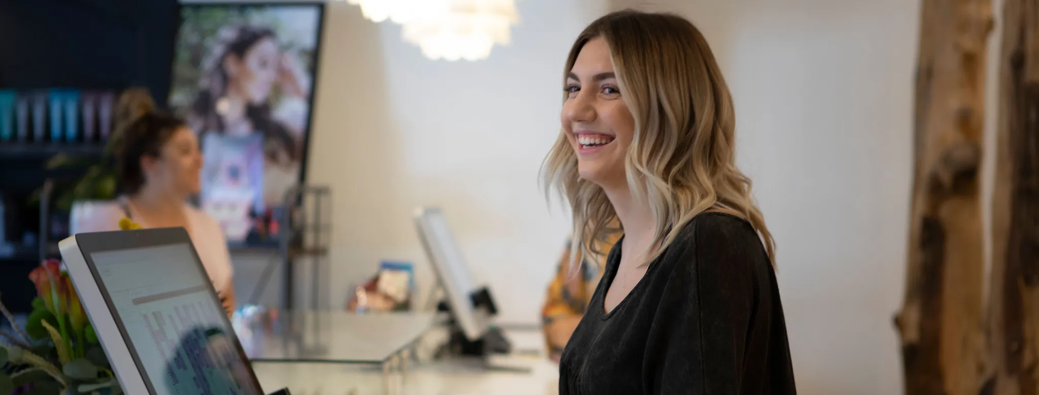 Woman at front desk smiles