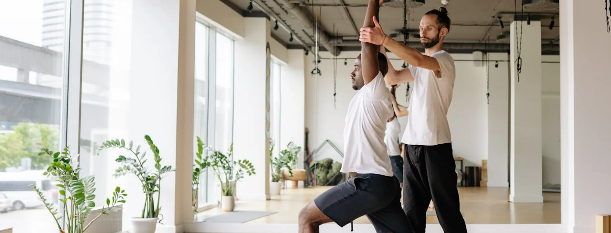 A man practicing yoga with an instructor